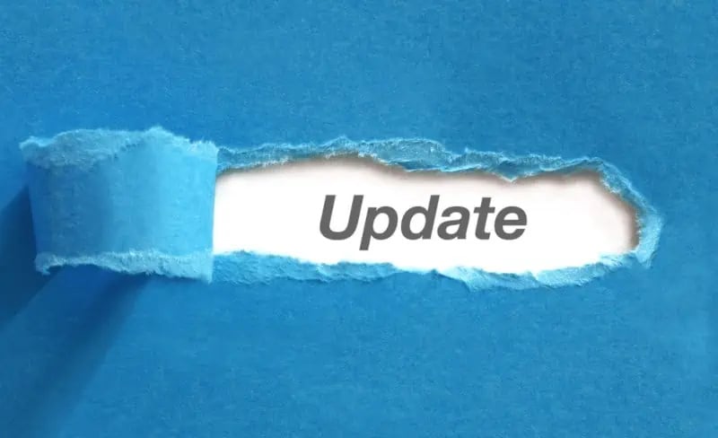 A torn strip of blue paper reveals the word Update printed in gray on a white background.